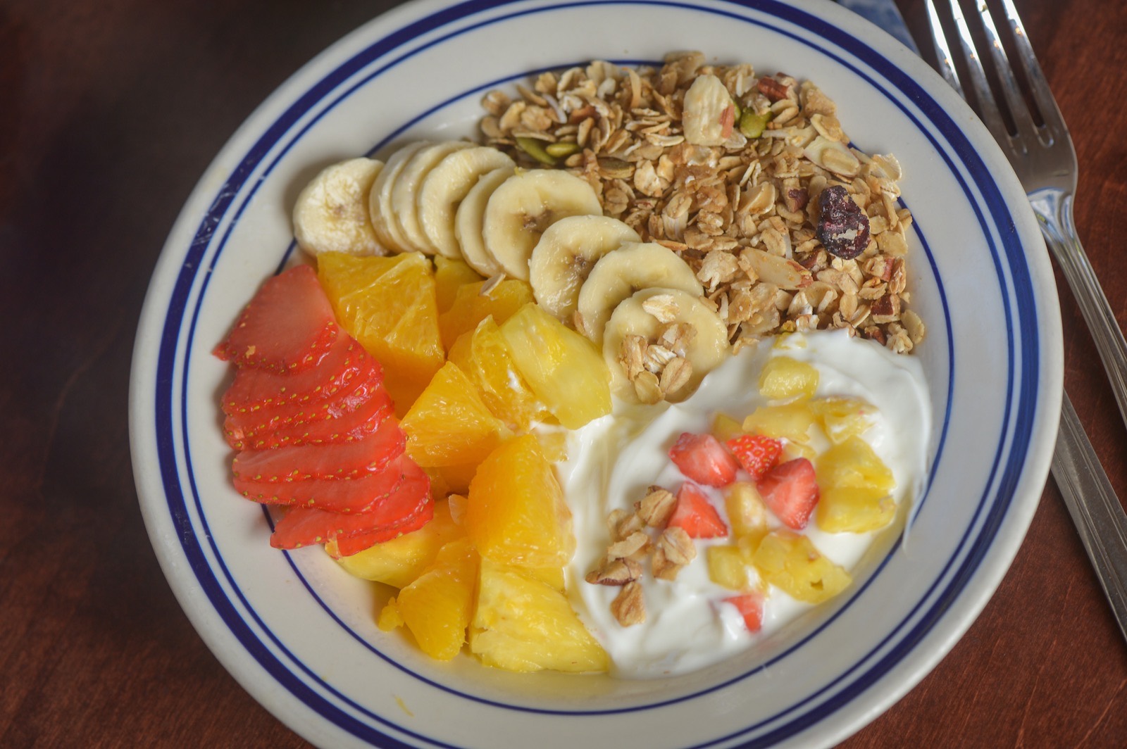 A granola, yogurt and fresh-fruit bowl on blue-rimmed Willow china.
