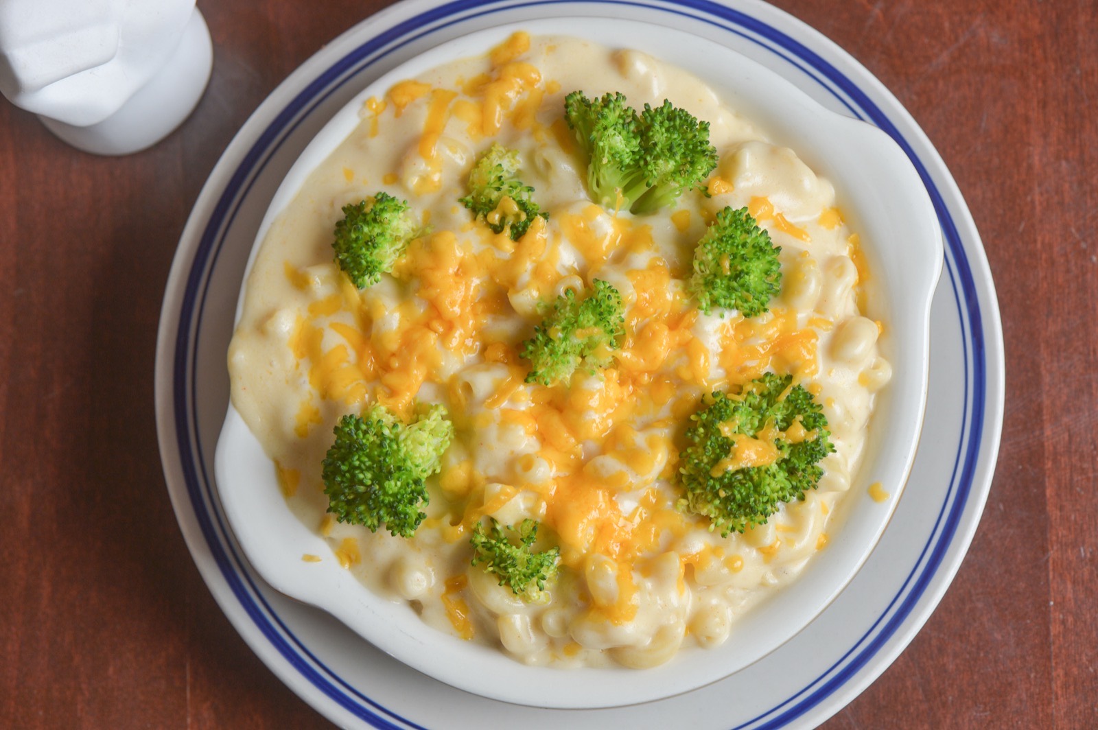 Macaroni and cheese with broccoli and cheddar on blue-rimmed Willow china.