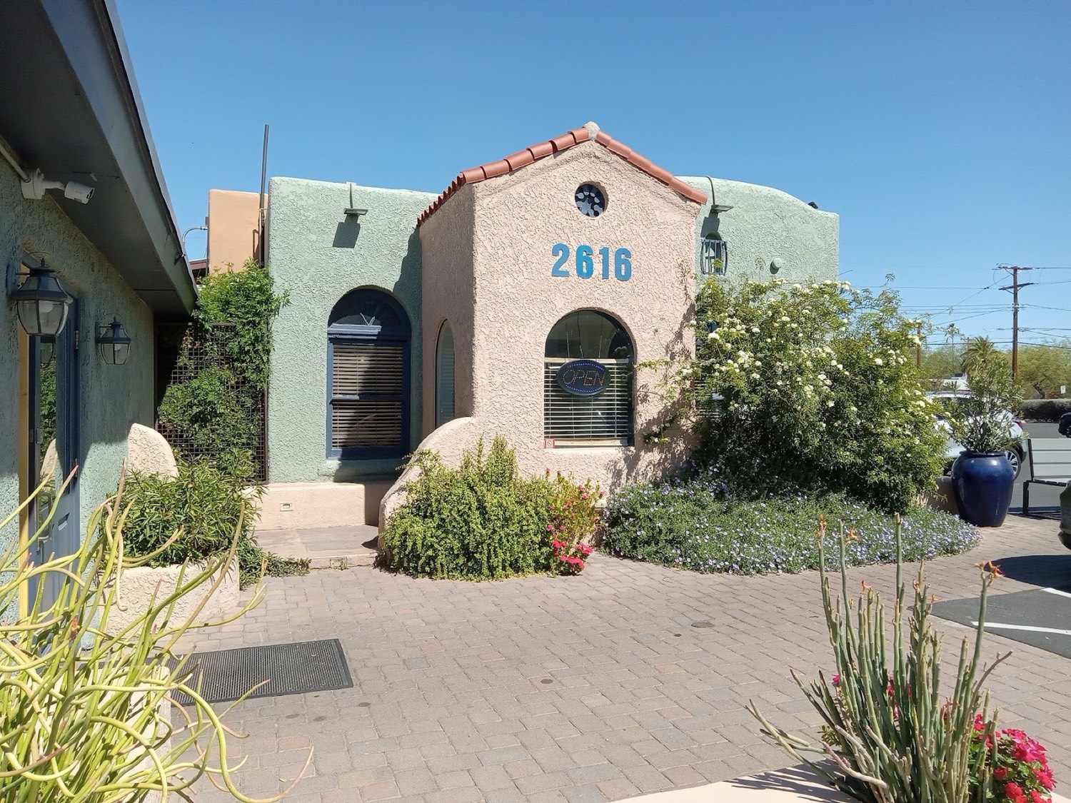The historic adobe home at 2616 North Campbell today, with arched windows, a tile roof and desert plantings.